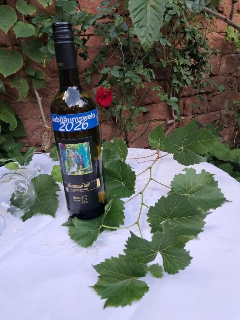 Eine Flasche Jubiläumswein Saint-Péray umgeben von Weinlaub