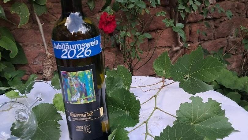 Eine Flasche Jubiläumswein Saint-Péray umgeben von Weinlaub