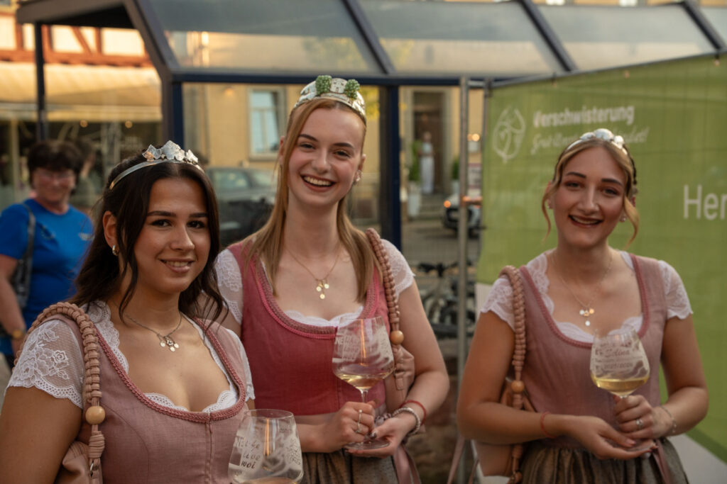 Rainhas do vinho de Groß-Umstadt, de copo na mão, na festa da geminação no parque Wendelinus