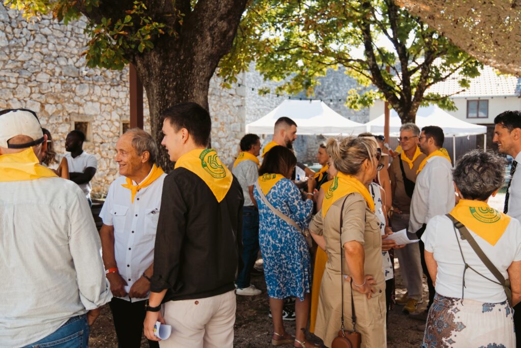 Delegationen mit gelb-grünen Halstüchern im Gespräch vor der Verschwisterungs-Zeremonie im Château de Beauregard in Saint-Péray